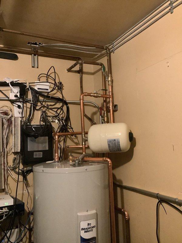 Installed 40-gallon Bradford White water heater, requiring rework of existing copper water lines to accommodate the taller tank configuration. Removed existing laundry sink and properly capped off associated water supply lines. Installation included mounting expansion tank, connecting copper supply and distribution piping with appropriate valves and fittings, and integrating all electrical connections to code. All plumbing connections tested and verified for proper operation and leak-free performance.