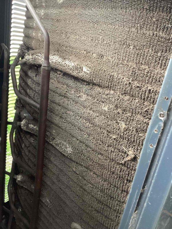 Completed comprehensive AC tune-up service on residential cooling system. Evaporator coil exhibited heavy dust and debris accumulation throughout the cross-hatched mesh surface, significantly restricting airflow and reducing system efficiency. Thoroughly cleaned coil to restore proper heat transfer capability and airflow. Inspected electrical components within control panel and identified capacitor with severe corrosion and oxidation on terminals and metal cap, presenting potential failure risk. Recommended immediate capacitor replacement to prevent system breakdown. Verified all electrical connections, tested system operation, and documented equipment condition with photographic evidence for customer records.