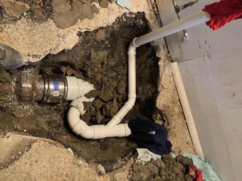 Completed comprehensive basement bathroom renovation including removal of existing shower unit and concrete excavation to facilitate complete replumbing of drainage system. Installed new Aker 32x32x76 four-piece shower enclosure with framing for left side wall. Jackhammered and excavated concrete flooring to relocate and replumb drain lines for toilet, lavatory with air admittance valve, and shower. Relocated floor drain to position under existing laundry tub. Installed new PVC drainage piping with proper trap configuration throughout excavated area. Repositioned water supply connections for toilet and lavatory to accommodate homeowner-supplied vanity cabinet. Installed condensate pump system with PVC piping to redirect furnace condensate drainage. Repoured concrete flooring following completion of all plumbing rough-in work and drainage modifications. All fixtures tested and operational upon completion.