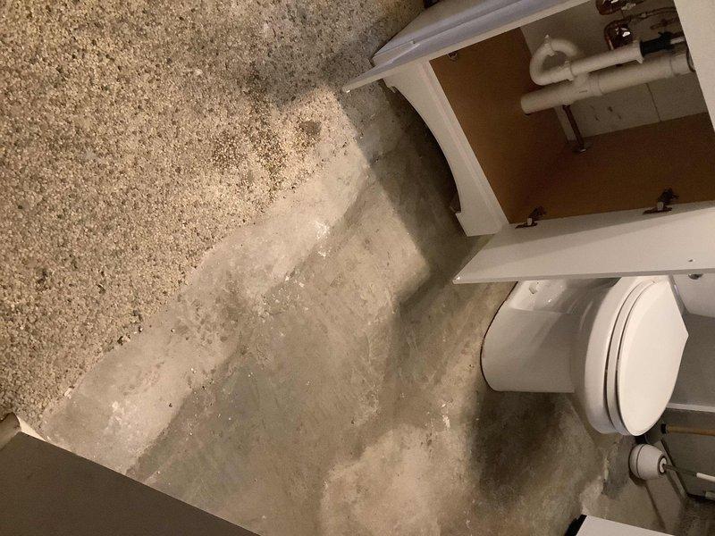 Completed comprehensive basement bathroom renovation including removal of existing shower unit and concrete excavation to facilitate complete replumbing of drainage system. Installed new Aker 32x32x76 four-piece shower enclosure with framing for left side wall. Jackhammered and excavated concrete flooring to relocate and replumb drain lines for toilet, lavatory with air admittance valve, and shower. Relocated floor drain to position under existing laundry tub. Installed new PVC drainage piping with proper trap configuration throughout excavated area. Repositioned water supply connections for toilet and lavatory to accommodate homeowner-supplied vanity cabinet. Installed condensate pump system with PVC piping to redirect furnace condensate drainage. Repoured concrete flooring following completion of all plumbing rough-in work and drainage modifications. All fixtures tested and operational upon completion.