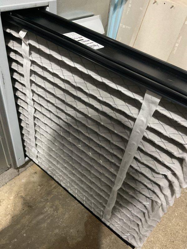 Completed Early Bird A/C Tune-Up on residential cooling system per customer request. Performed comprehensive inspection of outdoor condensing unit, noting significant dust and debris accumulation on condenser coils with visible brownish-gray discoloration affecting heat transfer efficiency. Inspected indoor air filter, which showed moderate dust loading but remained serviceable. Documented unit condition with photographs showing horizontal fin coils requiring attention and filter assembly with proper installation. System operational at time of service with fan assembly functioning normally.