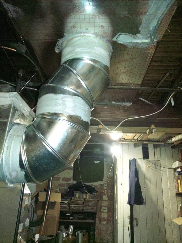 Completed full HVAC system installation in basement utility space, including 80% efficiency furnace unit, air conditioning system, and 40-gallon water heater. Installed and connected metallic spiral ductwork with proper insulation wrapping at connection points, configured rectangular sheet metal ducts and flexible round ducting to furnace unit. Mounted furnace against concrete block wall, integrated humidifier or air quality device with white PVC piping, and ensured all equipment properly positioned and secured with appropriate ventilation routing through exposed ceiling joists.