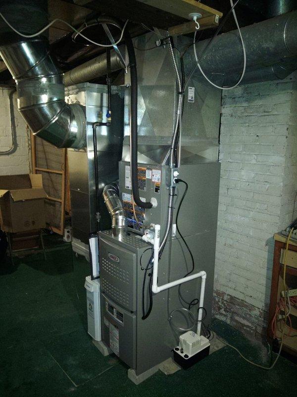 Completed full HVAC system installation in basement utility space, including 80% efficiency furnace unit, air conditioning system, and 40-gallon water heater. Installed and connected metallic spiral ductwork with proper insulation wrapping at connection points, configured rectangular sheet metal ducts and flexible round ducting to furnace unit. Mounted furnace against concrete block wall, integrated humidifier or air quality device with white PVC piping, and ensured all equipment properly positioned and secured with appropriate ventilation routing through exposed ceiling joists.