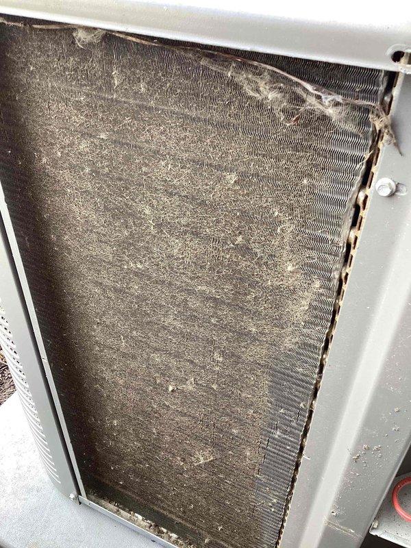 Completed preventive maintenance tune-up on a 3-year-old residential air conditioning system. Performed comprehensive inspection of indoor furnace components and outdoor condensing unit. Outdoor condenser coil exhibited heavy accumulation of dirt, dust, and debris throughout the fin surfaces, with particularly dense buildup in the central and upper portions; cleaned coil to restore proper airflow and heat transfer efficiency. Noted minor fin damage on right side of coil during inspection. Verified all electrical connections, checked refrigerant pressures, and confirmed proper system operation. Indoor furnace unit inspected with blower motor, gas valve, and control wiring all found in acceptable condition. System operating within normal parameters upon completion. Documented equipment condition with photographs for service records.