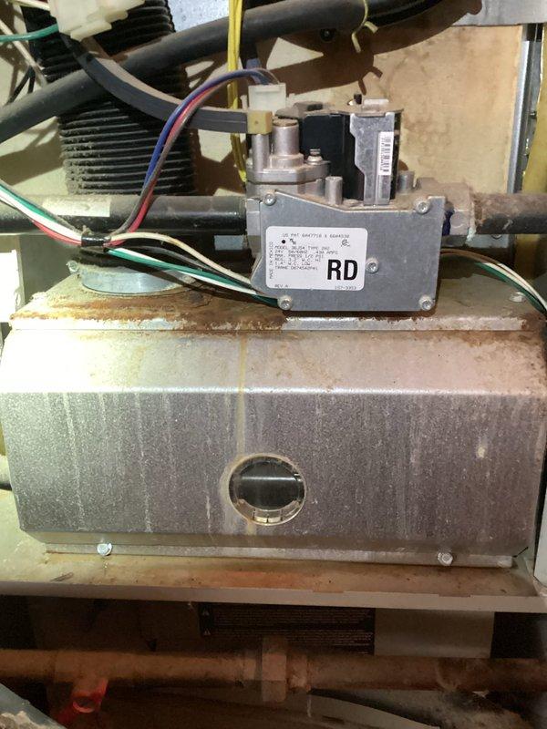 Completed MVP heating maintenance visit on residential HVAC system. Performed comprehensive inspection of gas furnace components including gas control valve assembly, burner chamber, and heat exchanger. Documented condition of equipment showing age-related wear patterns and rust discoloration on burner chamber surfaces. Inspected refrigeration circuit components including brass flow control valve, copper refrigerant lines, filter drier, and associated piping connections with insulation intact and properly maintained.