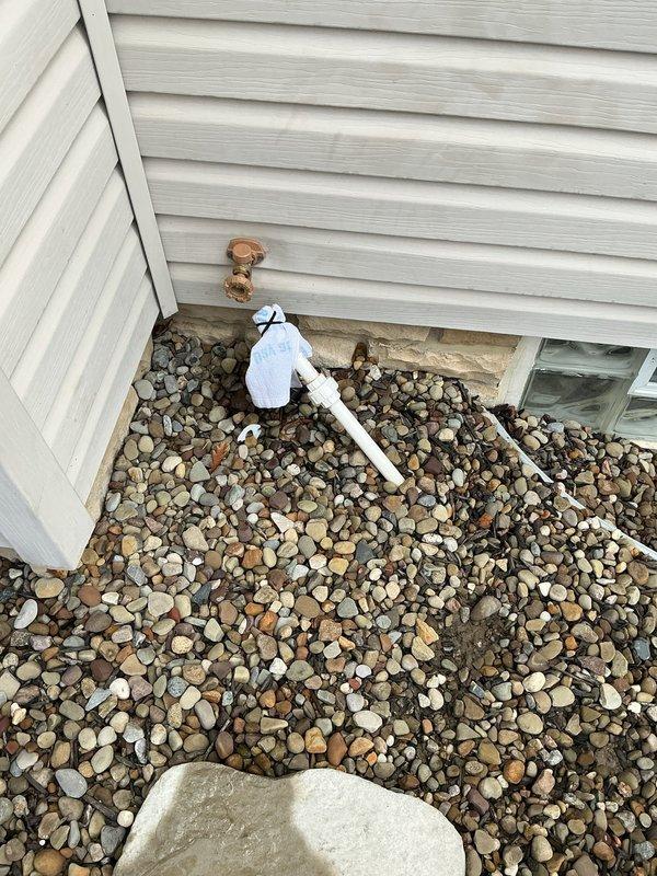 Replaced failed outdoor faucet at rear of property due to cracked vacuum breaker lid causing water leak. Installed new Woodford frost-free faucet with necessary copper pipe and soldered coupling connection to existing water line. Verified proper operation and sealed penetration point through foundation to prevent water intrusion.