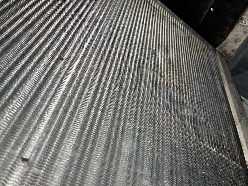 Performed routine HVAC maintenance on cooling system located in backyard. Inspected and evaluated air filter condition, noting dust accumulation and discoloration on pleated media. Examined condenser coil fins, observing minor debris accumulation and typical operational wear on aluminum fin surfaces. System components assessed and documented through photographic records for maintenance history.