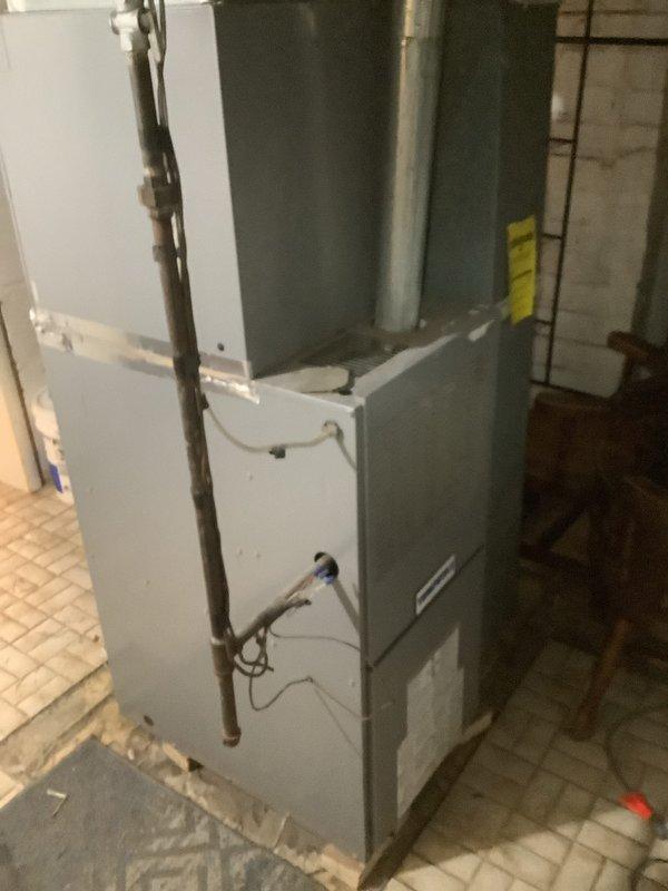 Completed full HVAC system installation including an 80% efficiency furnace unit in the basement mechanical room and a matching air conditioning condenser unit on the exterior of the property. The furnace was installed with proper ductwork connections, copper refrigerant line sets, electrical wiring, and all necessary safety controls. The outdoor condenser was positioned in a corner location against the brick foundation with adequate clearance for airflow and future service access. All components were tested and verified operational upon completion.