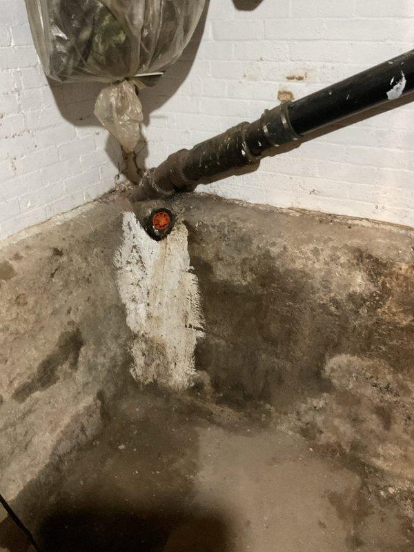 Responded to sewer line backup at residential property over 100 years old. Upon arrival, accessed basement utility area via back entrance and assessed plumbing system. Located main sewer line obstruction causing backup into basement floor drain area. Utilized professional drain cleaning equipment to clear blockage from aged cast iron and PVC piping system. Extensive water staining on concrete floor indicated previous drainage issues consistent with aging infrastructure. Successfully restored proper flow and drainage through main sewer line. Tested system operation and confirmed full functionality of floor drain and connected plumbing fixtures. Documented existing conditions of aged plumbing components including deteriorated vertical stack and insulated waste lines for maintenance records.