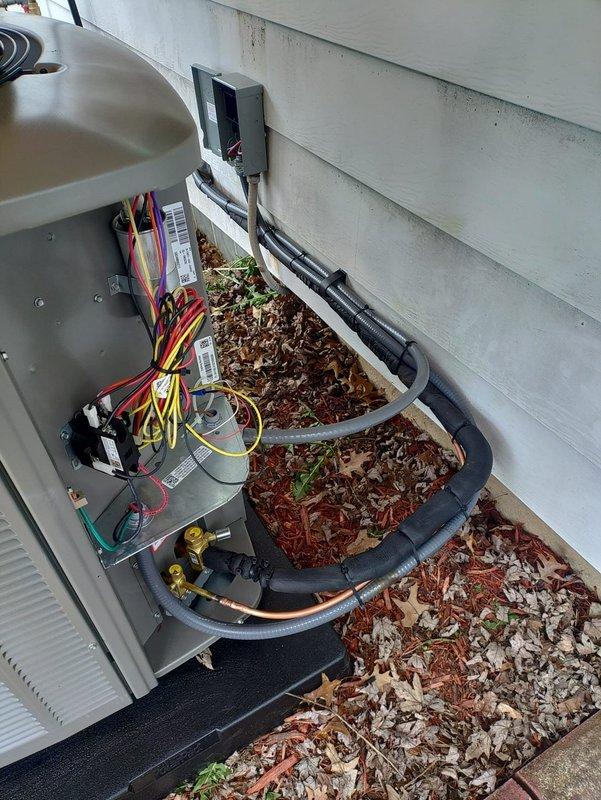 Completed full HVAC system installation including furnace, air conditioning unit, tankless water heater, and sump pump. Installed outdoor condensing unit with proper refrigerant line connections utilizing black foam insulation and copper piping, secured electrical wiring harness with multi-conductor connections to contactor assembly, and mounted disconnect box on exterior wall per code requirements. All equipment installed on appropriate pads, tested for proper operation, and verified electrical connections at all termination points.