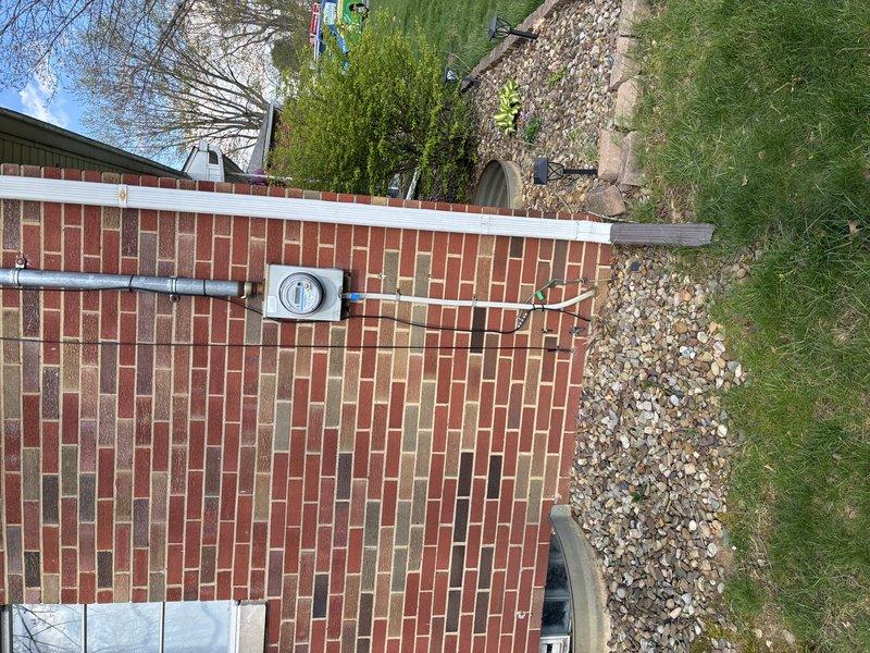 Conducted site evaluation for electric vehicle charging station installation at residential brick building. Assessed existing electrical service and meter location on exterior wall, documented current electrical infrastructure including conduit routing and utility connections. Photographed building exterior, electrical meter box, and proposed installation pathway to determine optimal charger placement and required materials. Evaluated electrical panel capacity and distance from meter to proposed charging location. Prepared comprehensive estimate for EVSE installation including necessary electrical upgrades, conduit runs, and dedicated circuit requirements to support Level 2 charging equipment.