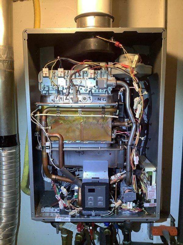 Performed descaling maintenance on a 13-year-old Rinnai natural gas tankless water heater. Flushed the heat exchanger with descaling solution to remove mineral buildup and restore optimal heating efficiency. Inspected internal components, verified proper operation of gas valves and controls, and confirmed unit returned to normal function upon completion.