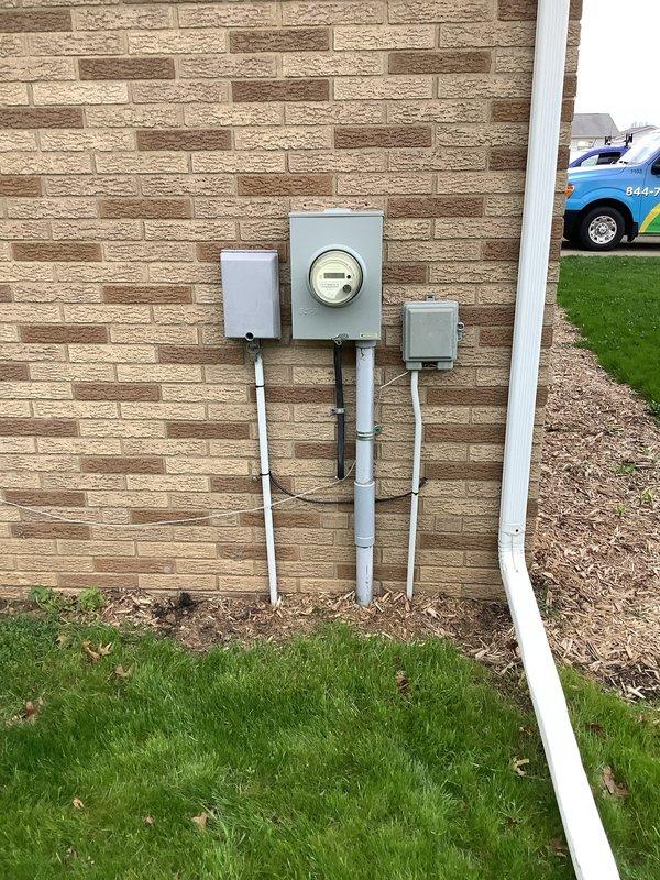 Conducted electrical estimate for 200-amp panel upgrade in basement. Evaluated existing electrical panel mounted on wooden board against concrete block wall, assessed current breaker configuration and wire routing through ceiling joists, and inspected exterior meter base and service entrance equipment. Provided comprehensive assessment and pricing for complete service upgrade including new 200-amp main panel, proper grounding, and code-compliant installation.