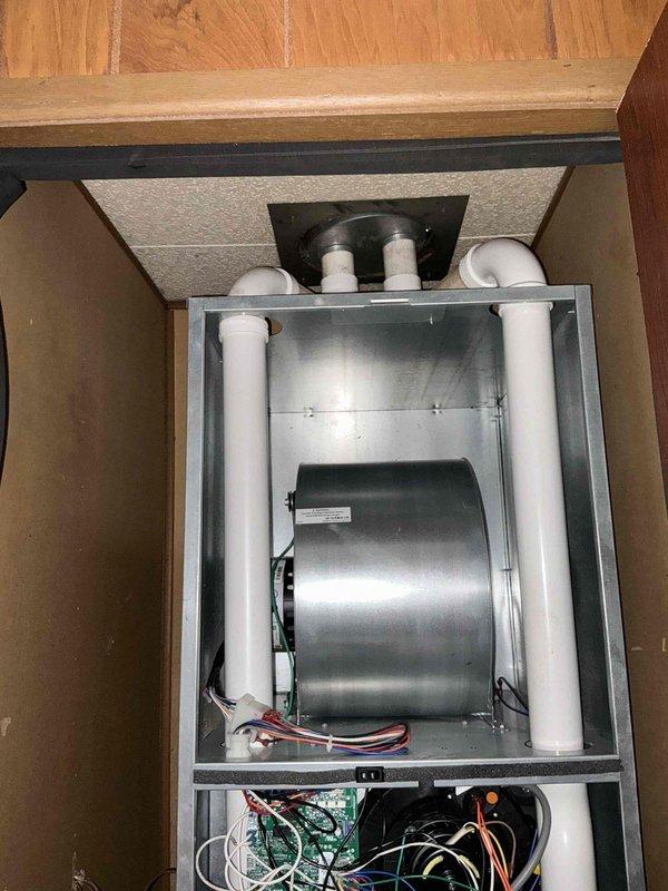 Completed estimate for adding air conditioning system to mobile home with existing heating unit. Assessed current vertical air handler installation housed in under-floor cabinet space and evaluated requirements for integrating cooling components including outdoor condensing unit, refrigerant line set, electrical upgrades, and condensate drainage modifications to create complete HVAC system.