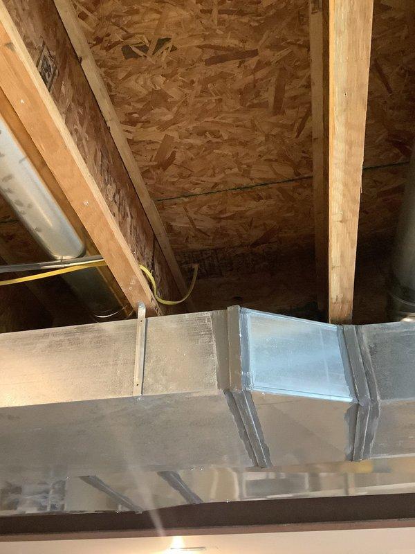 Installed new electrical line in 10-year-old residential property, routing wiring through attic crawl space alongside existing HVAC ductwork and structural framing. Work included running cable along wooden beams to designated termination point, installing electrical panel with cover plate in utility area, and ensuring proper clearances from metal ductwork per code requirements.