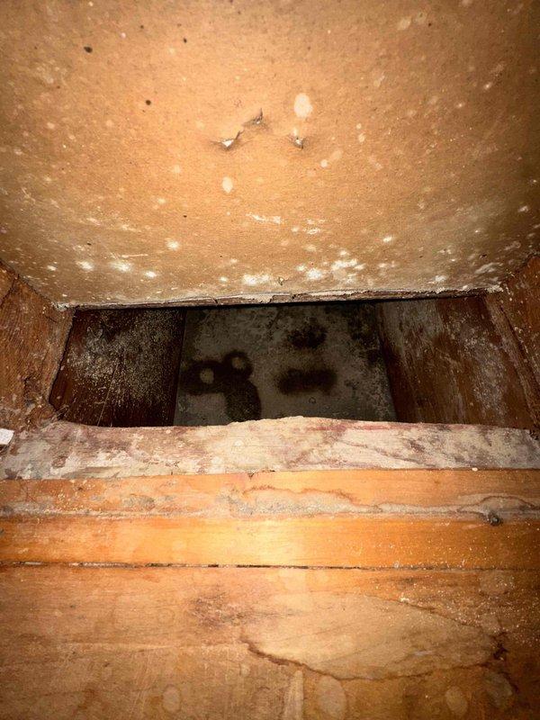 Completed comprehensive duct cleaning service with photographic documentation of system condition. Inspection revealed significant accumulation of dust and debris throughout the ventilation system, including thick sediment buildup on duct floors and particulate matter coating interior surfaces. Metal ductwork showed evidence of age-related deterioration with visible discoloration and weathering patterns. Cleaned rectangular supply or return trunk lines with heavy dust deposits on both horizontal and vertical surfaces. Accessed crawl space areas where wooden structural components exhibited moisture-related staining and contamination within floor joist cavities. Performed cleaning procedures to remove accumulated debris from accessible duct sections and documented pre-existing conditions including potential moisture intrusion issues in structural spaces adjacent to ductwork.