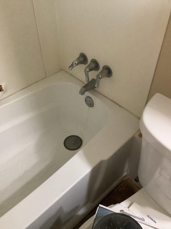 Responded to emergency call for malfunctioning bathtub faucet that could not be shut off, requiring main water supply to be turned off to stop flow. Inspected 10-year-old three-handle chrome faucet system on 40-year-old plumbing infrastructure. Assessed condition of existing fixtures and determined replacement necessary. Inspected under-sink drains as requested and evaluated overall plumbing system condition. Provided customer with Moen replacement shower head options and discussed fixture upgrade recommendations to prevent future failures.