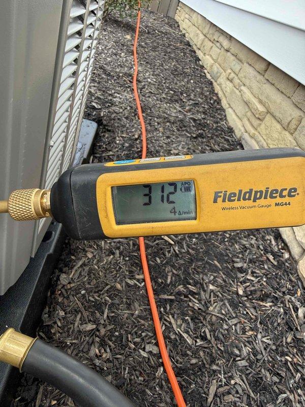 Completed installation of new air conditioning system and humidifier at residential property. Installed outdoor condenser unit on prepared mulch bed with proper clearances, ran refrigerant lines and electrical conduit to disconnect box mounted on exterior wall, and installed condensate drain line. System was evacuated to proper micron level as verified by vacuum gauge reading, pressure tested, and commissioned for operation.
