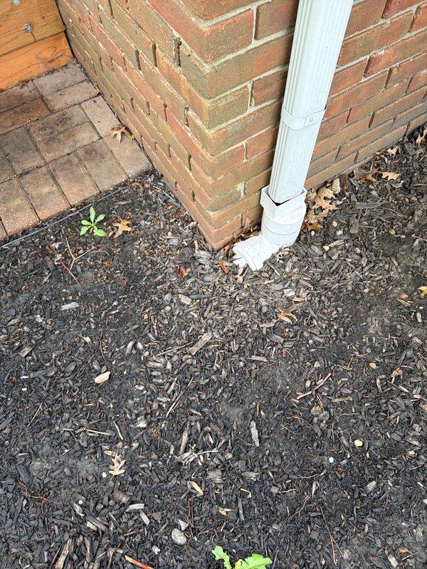 Responded to service call for clogged yard drainage system. Conducted on-site assessment of existing drainage infrastructure, including inspection of downspout discharge point at building foundation and in-ground storm drain grate in lawn area. Documented current conditions through photographic evidence showing debris accumulation around downspout base and storm drain location. Provided professional quote for installation of French drain system to improve yard drainage and prevent water pooling issues near foundation.