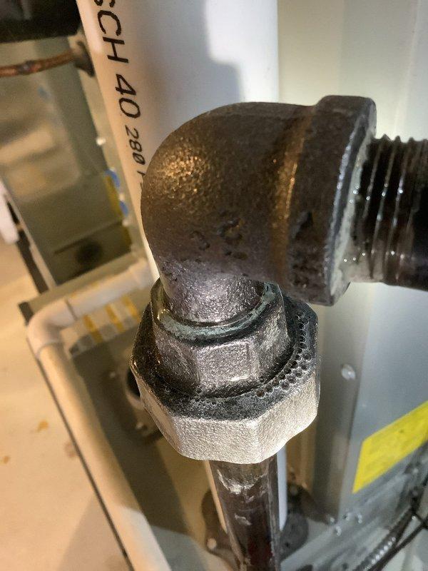 Responded to gas leak emergency at furnace location in basement. Upon arrival, confirmed gas supply had been isolated by electrical contractor who identified leak at threaded union connection on furnace gas line. Conducted visual inspection of the corroded union fitting, which displayed significant oxidation and deterioration at the threaded connection point. Performed comprehensive pressure test on entire gas piping system to verify isolation of leak and confirm no additional leaks present in downstream or upstream lines. Test confirmed leak was isolated to the single union connection at furnace inlet. Documented corroded pipe fitting and union connection with photographs showing extensive mineral deposits and deterioration of threaded components. Gas supply remains shut off pending replacement of failed union fitting. Recommend immediate replacement of corroded gas line union and full system pressure test upon completion of repair before restoring gas service to furnace.
