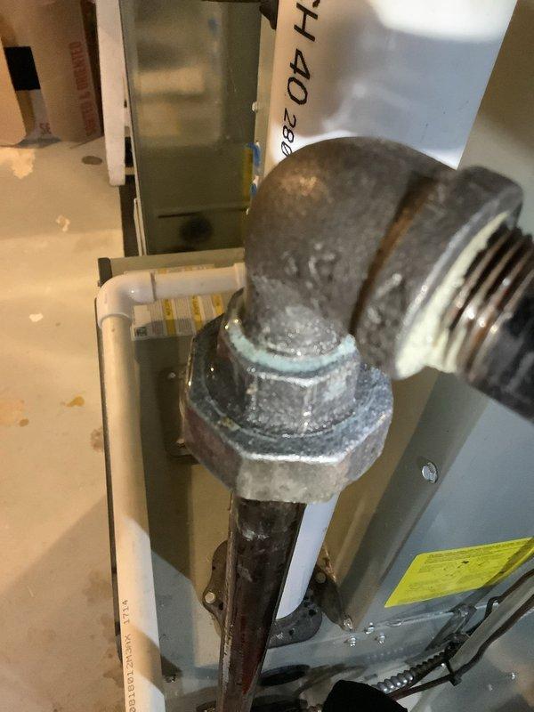 Responded to gas leak emergency at furnace location in basement. Upon arrival, confirmed gas supply had been isolated by electrical contractor who identified leak at threaded union connection on furnace gas line. Conducted visual inspection of the corroded union fitting, which displayed significant oxidation and deterioration at the threaded connection point. Performed comprehensive pressure test on entire gas piping system to verify isolation of leak and confirm no additional leaks present in downstream or upstream lines. Test confirmed leak was isolated to the single union connection at furnace inlet. Documented corroded pipe fitting and union connection with photographs showing extensive mineral deposits and deterioration of threaded components. Gas supply remains shut off pending replacement of failed union fitting. Recommend immediate replacement of corroded gas line union and full system pressure test upon completion of repair before restoring gas service to furnace.