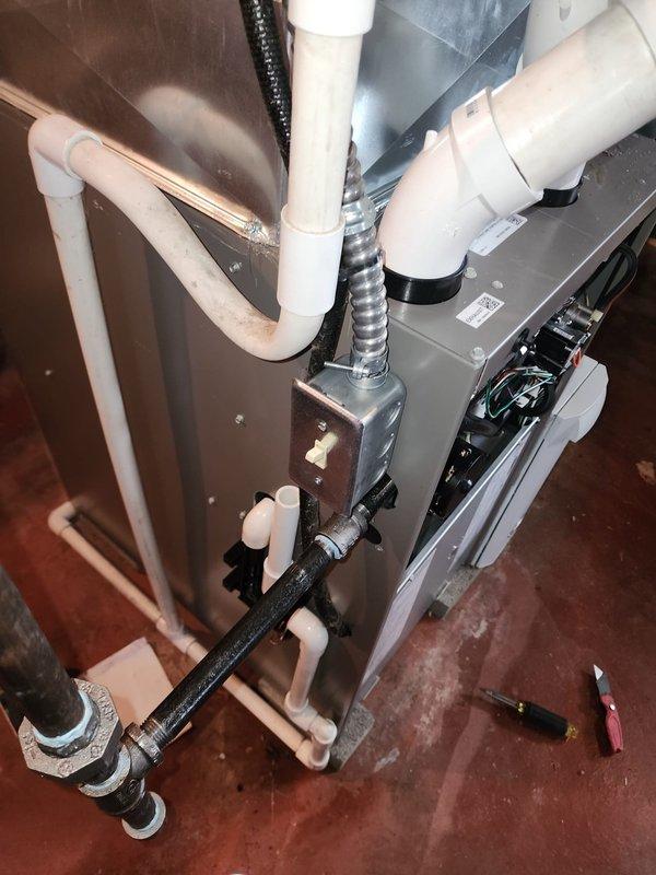 Completed full HVAC system installation including 80% AFUE furnace and air conditioning unit in basement utility area. Installed new air handler with proper electrical connections and junction box wiring. Ran refrigerant lines with appropriate insulation wrapping from condensing unit to air handler. Installed PVC condensate drain piping with proper pitch and mounting brackets secured to wall framing. Connected flexible metal conduit for electrical service and mounted all components to manufacturer specifications. Routed metallic flexible ductwork for supply air distribution. System tested and operational upon completion.