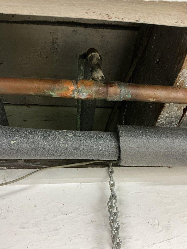 Completed water line installation and connection to Rheem Performance tanked water heater. Connected hot and cold water supply lines using copper piping with shut-off valves featuring red handles installed at the top of the unit for proper water flow control and future maintenance access. All connections were secured with threaded fittings and compression nuts to ensure leak-free operation, and the unit was verified to be properly positioned and ready for service.