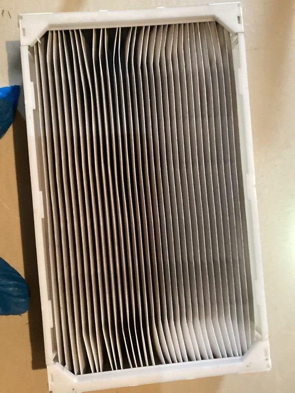 Completed recurring preventive maintenance inspection on HVAC system. Inspected and documented condition of air filtration components, including standard pleated air filter showing moderate dust accumulation and evaporative cooling pad exhibiting mineral deposits and discoloration from extended use. System components photographed for maintenance records.