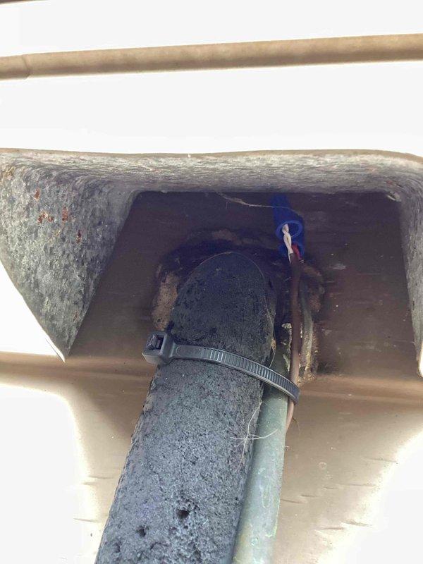 Responded to no cooling call on 4-year-old air conditioning system. Found outdoor condensing unit operational but indoor blower motor not running. Upon inspection, discovered significant debris accumulation including dried leaves around outdoor unit and visible corrosion on blower motor mounting plate and electrical connections. Identified failed blower motor as root cause of no airflow condition. Documented corroded components and deteriorated wiring connections with blue wire terminals showing rust damage. Presented repair options and discussed preventative maintenance program benefits. Customer declined membership plan and authorized diagnostic fee only. No repairs performed at this time.