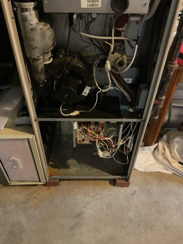 Responded to no-cooling call on 20+ year old air conditioning system. Upon arrival, found evaporator coil frozen with ice accumulation and outdoor condenser fan motor inoperative. Inspected indoor furnace unit and confirmed restricted airflow contributing to freeze-up condition. Examined outdoor condenser unit and verified fan motor failure preventing proper heat rejection. Documented equipment condition with photographs showing aged system components, dirty condenser coils with debris accumulation in mulch bed area, and compromised airflow through protective guard. Advised customer of system age, failed components, and benefits of system replacement options including maintenance plan coverage.
