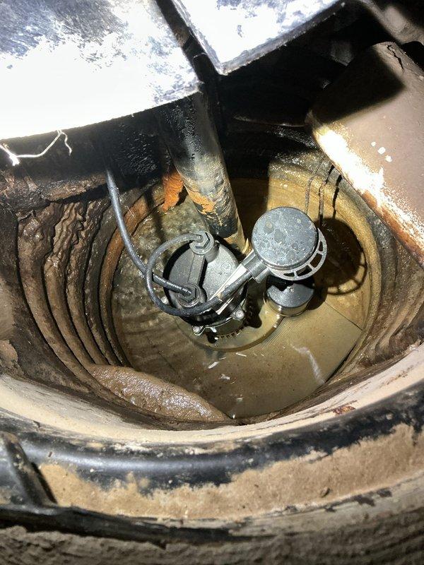 # Sump Pump Noise Evaluation and Consultation

Responded to service call regarding excessive noise from recently installed sump pump system. Performed comprehensive assessment of sump pump assembly, including inspection of pump unit, basin configuration, discharge piping, and mounting setup. Documented existing installation with detailed photographs showing pump positioning within basin, float switch assembly, PVC discharge piping configuration, and overall mechanical setup.

Evaluated potential noise sources including pump vibration against basin walls, improper mounting, discharge pipe resonance, and mechanical operation of float mechanism. Inspected chrome-colored float switch assembly and dark pump housing for proper clearance and secure positioning within corrugated basin. Assessed PVC discharge piping for proper support and potential vibration transmission through rigid connections.

Provided customer with multiple options to reduce operational noise levels, including: installati