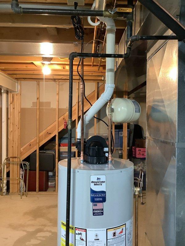 Replaced existing Rheem power vent water heater with new Bradford White 50-gallon residential tank water heater in basement utility area. Installed new thermal expansion tank and connected all necessary plumbing lines including hot and cold water supply pipes, gas line, and venting system. Removed old unit and staged new equipment with water heater installation kit, completing all copper piping connections, electrical wiring, and safety components. Tested system for proper operation, verified all connections for leaks, and ensured compliance with plumbing codes. Unit backed by 6-year manufacturer warranty and fully operational upon completion.