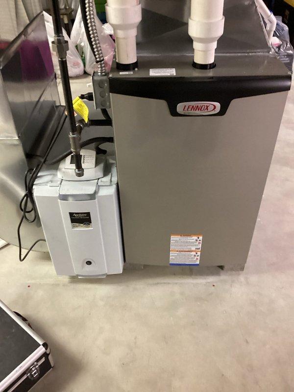 Completed scheduled MVP heating maintenance visit on Lennox furnace system. Inspected and photographed air filter showing moderate dust and debris accumulation with yellowish-brown discoloration throughout the metal mesh construction. Verified all system components including condensate pump, PVC venting, and electrical connections operating within normal parameters. Unit found in good overall condition with no immediate repairs required.