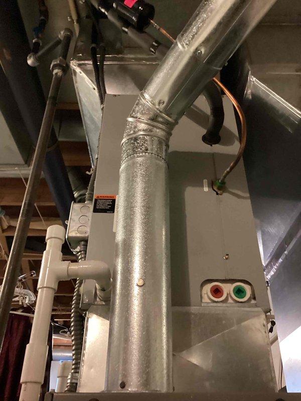 Completed MVP recurring cooling maintenance visit on residential HVAC system located in crawl space/basement area. Performed comprehensive inspection of air handler unit, ductwork, refrigerant lines, and condensate drainage system. All components found operating within normal parameters with appropriate condensation present on supply duct indicating active cooling mode. Verified proper operation of system controls and status indicators. Documented equipment condition through photographic records showing air handler cabinet, insulated refrigerant lines with proper connection caps, PVC condensate drain lines, and sealed ductwork connections.