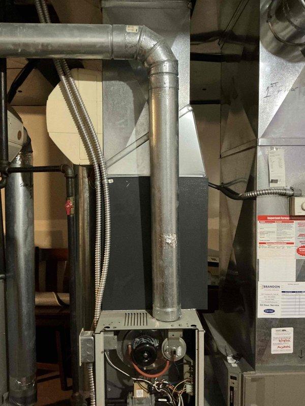 Completed comprehensive HVAC system replacement estimate for dual furnace and air conditioning units under buy-one-get-one promotion. Assessed existing basement installation including current air handling unit, galvanized ductwork configuration, and electrical connections. Documented existing system components through detailed photography showing furnace with exposed burner assembly, copper tubing, associated ductwork including horizontal and vertical runs with elbow joints, and flexible metal conduits for electrical and gas lines. Evaluated mechanical room setup for replacement feasibility and provided customer with equipment options and installation specifications for two complete HVAC systems.