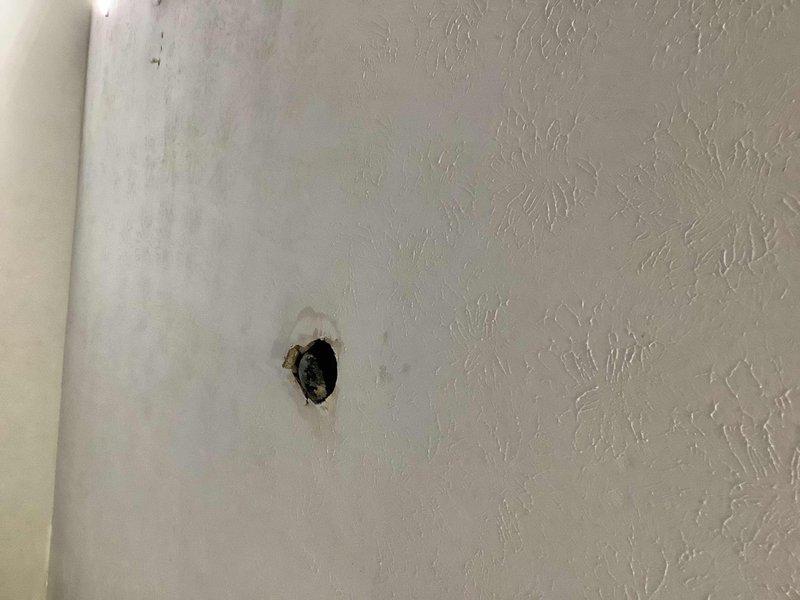 Responded to high-urgency plumbing emergency at 50-year-old duplex property experiencing simultaneous water leak and drainage backup affecting both units. Upon arrival, assessed bathroom fixture backup impacting all plumbing in both sides of duplex, with active water leak penetrating bathroom floor and discharging into garage area below. Investigated drainage system and identified blockage causing backup throughout shared plumbing infrastructure. 

Accessed both units using provided entry methods to evaluate extent of damage and locate source of failures. Inspected well water pump system and supply lines. Documented ceiling damage in garage where water intrusion had occurred, showing evidence of prolonged moisture exposure and structural compromise to ceiling material. Photographed affected areas including damaged ceiling with water-related deterioration and outdoor inspection points along property perimeter where underground plumbing infrastructure was marked for reference.

Cleared m