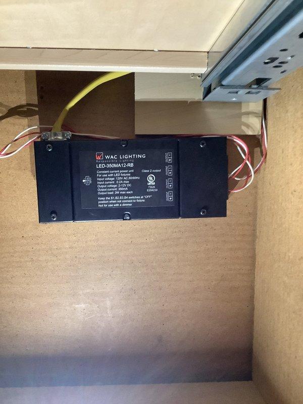 Responded to service call for intermittent under-cabinet lighting and outdoor GFCI outlets tripping during rain. Diagnosed failed LED driver for under-cabinet lighting system. Located WAC Lighting LED-350MA12-RB power supply mounted in cabinet with visible wire connections showing signs of thermal stress. Replaced defective driver with compatible MR-LED85 unit rated for appropriate voltage and wattage specifications. Verified proper wire terminations and secured new driver in cabinet space. Tested under-cabinet lighting operation through multiple on/off cycles to confirm stable performance. Inspected outdoor GFCI receptacles and identified moisture intrusion causing nuisance tripping. Recommended weather-resistant cover installation and verified GFCI functionality after cleaning contacts. All systems operational upon completion.