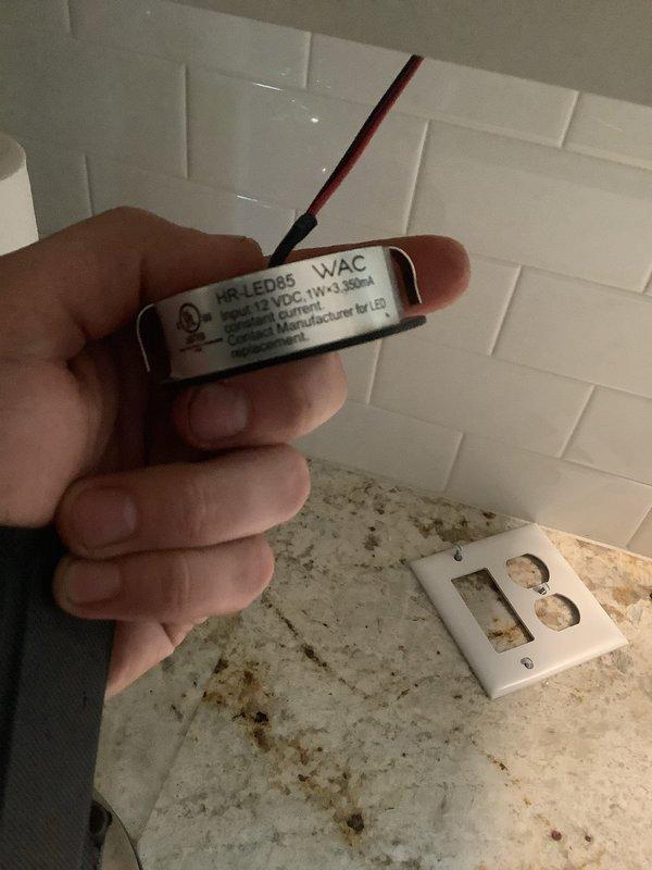 Responded to service call for intermittent under-cabinet lighting and outdoor GFCI outlets tripping during rain. Diagnosed failed LED driver for under-cabinet lighting system. Located WAC Lighting LED-350MA12-RB power supply mounted in cabinet with visible wire connections showing signs of thermal stress. Replaced defective driver with compatible MR-LED85 unit rated for appropriate voltage and wattage specifications. Verified proper wire terminations and secured new driver in cabinet space. Tested under-cabinet lighting operation through multiple on/off cycles to confirm stable performance. Inspected outdoor GFCI receptacles and identified moisture intrusion causing nuisance tripping. Recommended weather-resistant cover installation and verified GFCI functionality after cleaning contacts. All systems operational upon completion.