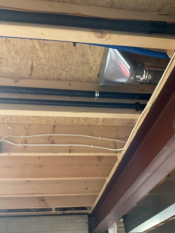 Completed installation of 18 KW Generac standby generator with 200 amp automatic transfer switch for Ohio Edison power service. Ran approximately 30 feet of gas piping through basement ceiling joists to fuel supply location, securing lines with appropriate mounting brackets and clamps alongside existing utility infrastructure. Installed transfer switch and coordinated with utility company for disconnect requirements to ensure proper integration with electrical service.