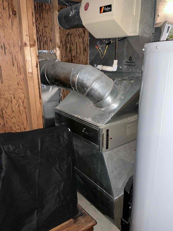 Completed HVAC estimate for residential furnace and air conditioning system replacement in basement utility area. Evaluated existing gray metal furnace unit with connected ductwork, air handler with curved galvanized metal supply duct, and assessed compatibility with current infrastructure including water heater placement. Provided customer with pricing options for complete furnace and AC replacement versus AC unit only replacement, documenting equipment specifications, installation requirements, and system configuration for quote preparation.