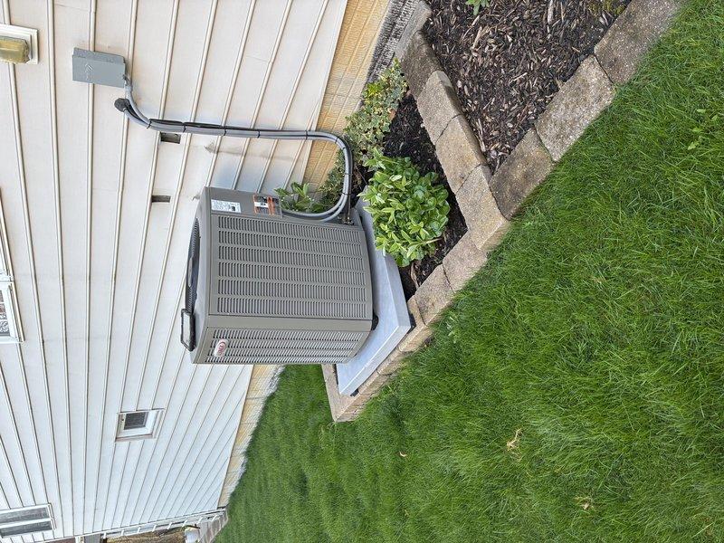 Responded to callback regarding AC unit stability concerns following installation. Upon arrival, inspected outdoor condenser unit and found equipment properly positioned on concrete pad consisting of multiple pavers arranged in rectangular configuration. Unit exhibited no signs of instability or improper installation. Verified all refrigerant lines, electrical connections, and conduit properly secured to exterior wall. Confirmed concrete pad installation meets manufacturer specifications and industry standards. Equipment operating within normal parameters with no structural or mechanical issues identified. Documented installation with photographs showing stable mounting, proper clearances, and professional workmanship. Customer concerns addressed through visual inspection and explanation of proper installation methods.