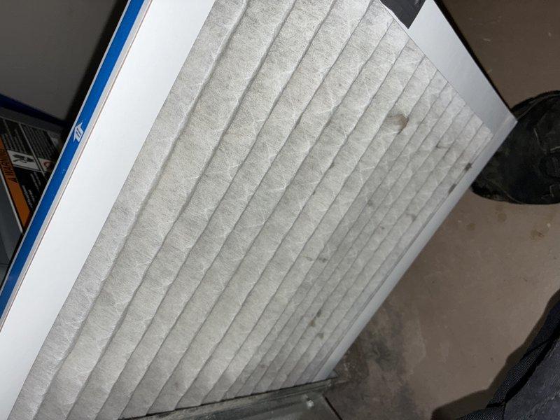 Performed routine maintenance visit on 13-year-old air conditioning system. Inspected evaporator coil and noted dust accumulation on fins; examined refrigerant lines showing normal aging and discoloration. Checked air filter which displayed moderate dirt buildup and documented system condition with photos for maintenance records.