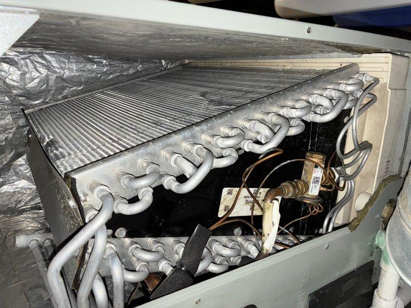 Performed routine maintenance visit on 13-year-old air conditioning system. Inspected evaporator coil and noted dust accumulation on fins; examined refrigerant lines showing normal aging and discoloration. Checked air filter which displayed moderate dirt buildup and documented system condition with photos for maintenance records.