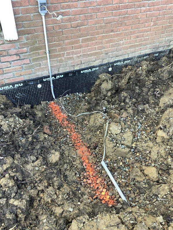 Responded to emergency electrical repair call for damaged wiring at commercial property undergoing foundation excavation work. Upon arrival, assessed electrical conduit and wiring that had been compromised multiple times during foundation waterproofing and drainage installation activities. The electrical line running along the exterior brick wall and into the excavation trench had become frayed and broken due to repeated contact with construction equipment and materials during the dig-out process. Repaired damaged electrical conduit and replaced compromised wiring to restore safe electrical service to the business facility.