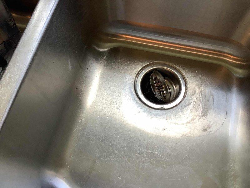 Responded to service call for kitchen sink drain repair and leaking toilet at residential property. Upon arrival, inspected kitchen sink drainage system and identified clog in main drain line. Cleared blockage using appropriate drain cleaning equipment and verified proper water flow through stainless steel sink basin and drain assembly. Inspected P-trap and drain connections under sink cabinet for any additional issues or leaks. Proceeded to second issue involving toilet leak. Diagnosed source of leak, performed necessary repairs to restore proper function and eliminate water seepage. Tested both fixtures to confirm all repairs were successful and systems operating correctly. Advised homeowner on proper maintenance practices for aging plumbing systems given the approximate 50-year age of the home's infrastructure.