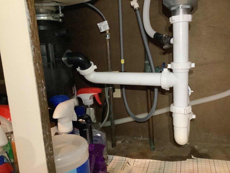 Responded to service call for kitchen sink drain repair and leaking toilet at residential property. Upon arrival, inspected kitchen sink drainage system and identified clog in main drain line. Cleared blockage using appropriate drain cleaning equipment and verified proper water flow through stainless steel sink basin and drain assembly. Inspected P-trap and drain connections under sink cabinet for any additional issues or leaks. Proceeded to second issue involving toilet leak. Diagnosed source of leak, performed necessary repairs to restore proper function and eliminate water seepage. Tested both fixtures to confirm all repairs were successful and systems operating correctly. Advised homeowner on proper maintenance practices for aging plumbing systems given the approximate 50-year age of the home's infrastructure.
