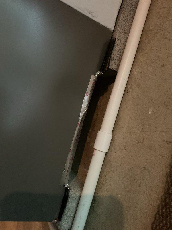 Responded to service call regarding newly installed air conditioning unit with reported damage to rear cabinet panel allowing excessive air leakage. Upon inspection, confirmed cabinet damage at back of outdoor unit with noticeable air escape from compromised section. Documented damage with photographs showing affected area and PVC refrigerant line routing for warranty claim processing and potential cabinet panel replacement.