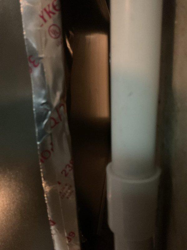 Responded to service call regarding newly installed air conditioning unit with reported damage to rear cabinet panel allowing excessive air leakage. Upon inspection, confirmed cabinet damage at back of outdoor unit with noticeable air escape from compromised section. Documented damage with photographs showing affected area and PVC refrigerant line routing for warranty claim processing and potential cabinet panel replacement.
