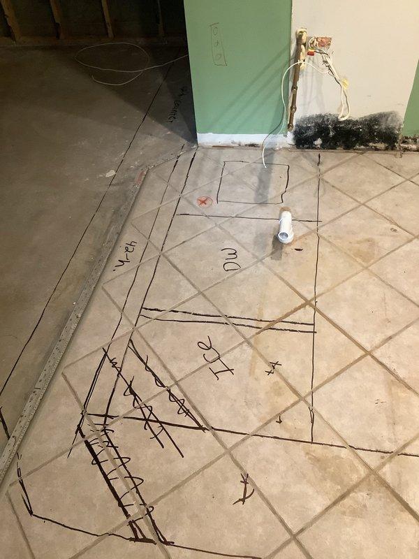 Completed new plumbing installation for sink drain and established electrical hookups for dishwasher, refrigerator, and ice maker as part of ongoing home renovation. Installed PVC drain stub-out through tile flooring and coordinated rough-in work with existing construction layout markings. Documented pre-existing conditions including wall damage and mold at baseboard level, and exposed electrical outlet requiring attention during renovation completion.