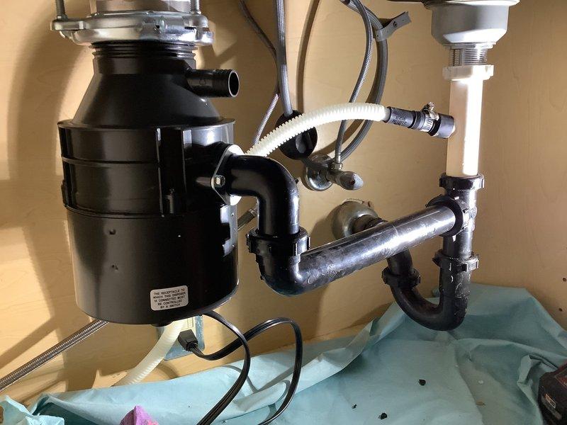 Provided quote for sump pump replacement at residential property. Upon inspection, assessed existing sump pump system and determined replacement requirements. Documented current plumbing configuration including under-sink assembly with garbage disposal unit, P-trap connections, and drain line routing for service records.